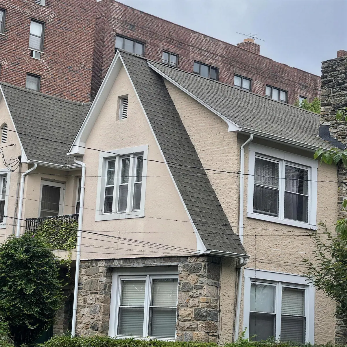 Casa de dos pisos con techo de tejas grises terminado por Ecua Roofing NY