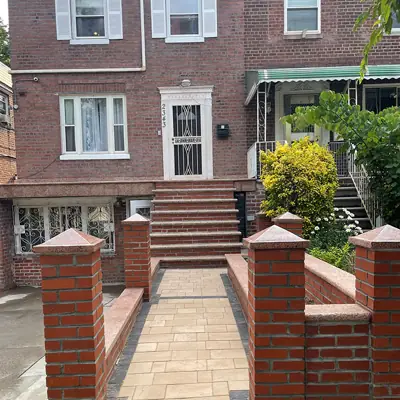 Fachada de ladrillo con escalera y muros de entrada