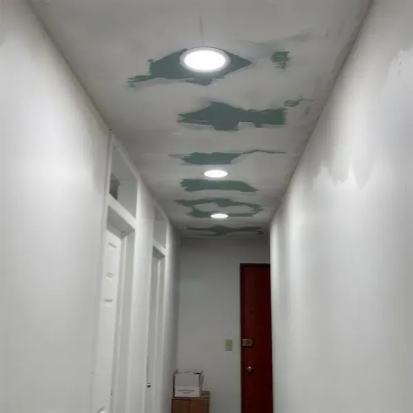 Pasillo con techo dañado por goteras, antes del arreglo